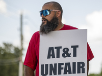 Unionized workers are picketing near the entrance of an AT&T facility in Daytona Beach, Florida, on August 20, 2024, as part of the Communic...