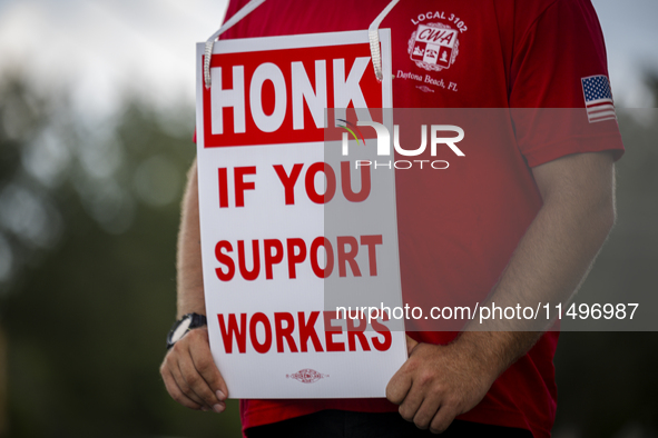 Unionized workers are picketing near the entrance of an AT&T facility in Daytona Beach, Florida, on August 20, 2024, as part of the Communic...