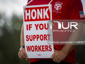 Unionized workers are picketing near the entrance of an AT&T facility in Daytona Beach, Florida, on August 20, 2024, as part of the Communic...