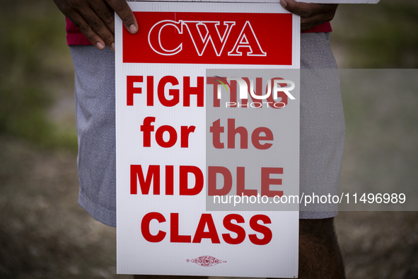 Unionized workers are picketing near the entrance of an AT&T facility in Daytona Beach, Florida, on August 20, 2024, as part of the Communic...