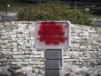 A vandalized stone plate with the words Plaza Hugo Chavez, President of Venezuela, is being seen near a billboard with the Spanish inscripti...