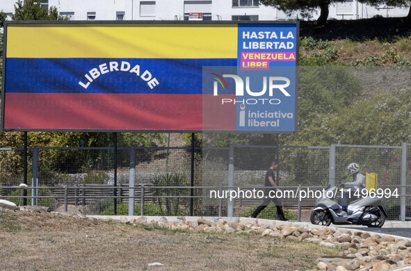 A person is walking near a billboard with the inscription in Spanish ''Venezuela Libre'' (free Venezuela) in the center of Lisbon, Portugal,...