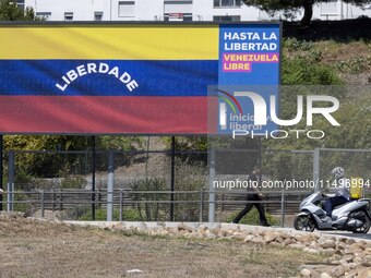 A person is walking near a billboard with the inscription in Spanish ''Venezuela Libre'' (free Venezuela) in the center of Lisbon, Portugal,...