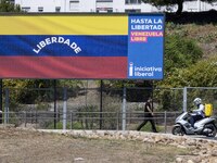 A person is walking near a billboard with the inscription in Spanish ''Venezuela Libre'' (free Venezuela) in the center of Lisbon, Portugal,...