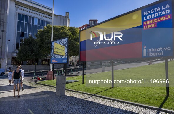 A person is walking near a billboard with the inscription in Spanish ''Venezuela Libre'' (free Venezuela) in the center of Lisbon, Portugal,...