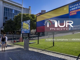 A person is walking near a billboard with the inscription in Spanish ''Venezuela Libre'' (free Venezuela) in the center of Lisbon, Portugal,...