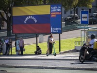 Several people are standing near a billboard with the inscription in Spanish ''Venezuela Libre'' (free Venezuela) in central Lisbon, Portuga...