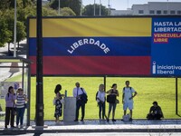 Several people are standing near a billboard with the inscription in Spanish ''Venezuela Libre'' (free Venezuela) in central Lisbon, Portuga...