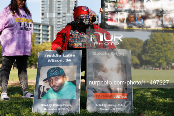 A demonstrator holds signs depicting people killed by the Chicago Police Department during a protest of the Revolutionary Communist Party at...