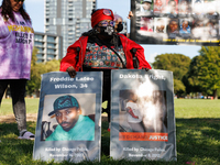 A demonstrator holds signs depicting people killed by the Chicago Police Department during a protest of the Revolutionary Communist Party at...