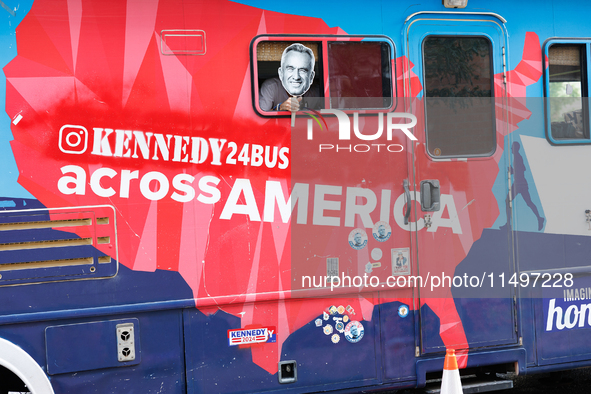 A person holds a sign depicting Robert F. Kennedy Jr. out of a window from a campaign bus near the Democratic National Convention in Chicago...