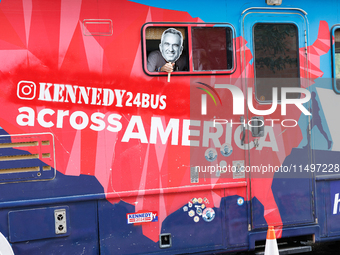 A person holds a sign depicting Robert F. Kennedy Jr. out of a window from a campaign bus near the Democratic National Convention in Chicago...