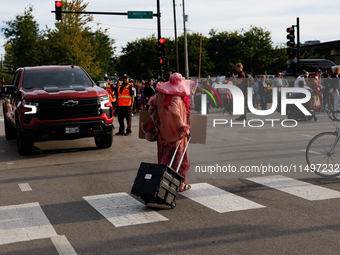 A demonstrator crosses a street near an entrance to the Democratic National Convention in Chicago, Illinois on August 20, 2024. (