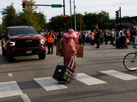 A demonstrator crosses a street near an entrance to the Democratic National Convention in Chicago, Illinois on August 20, 2024. (