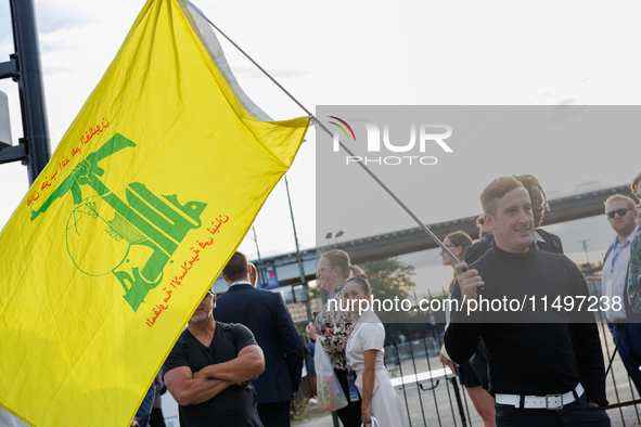 A person holds a flag of Hezbollah near an entrance to the Democratic National Convention in Chicago, Illinois on August 20, 2024. 