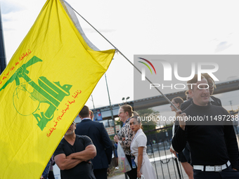 A person holds a flag of Hezbollah near an entrance to the Democratic National Convention in Chicago, Illinois on August 20, 2024. (