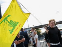 A person holds a flag of Hezbollah near an entrance to the Democratic National Convention in Chicago, Illinois on August 20, 2024. (