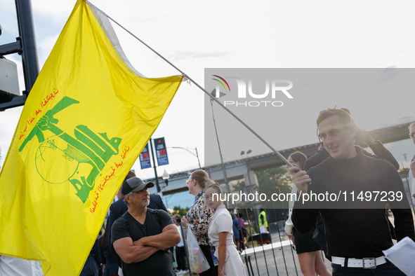 A person holds a flag of Hezbollah near an entrance to the Democratic National Convention in Chicago, Illinois on August 20, 2024. 