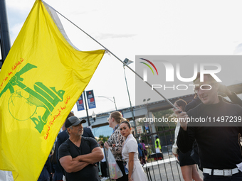 A person holds a flag of Hezbollah near an entrance to the Democratic National Convention in Chicago, Illinois on August 20, 2024. (