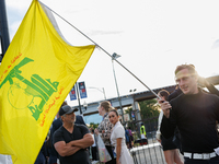 A person holds a flag of Hezbollah near an entrance to the Democratic National Convention in Chicago, Illinois on August 20, 2024. (