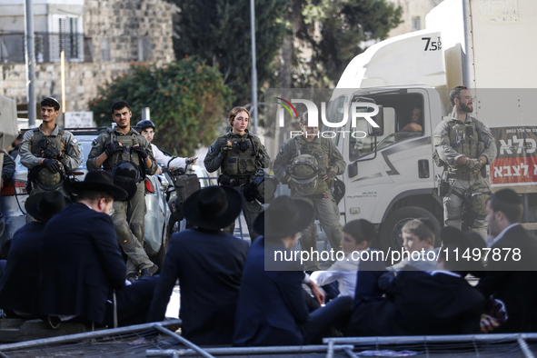 Israeli police officers intervene in Ultra-Orthodox Jews, also known as Haredim, who gather to stage a protest against mandatory military se...