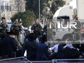 Israeli police officers intervene in Ultra-Orthodox Jews, also known as Haredim, who gather to stage a protest against mandatory military se...