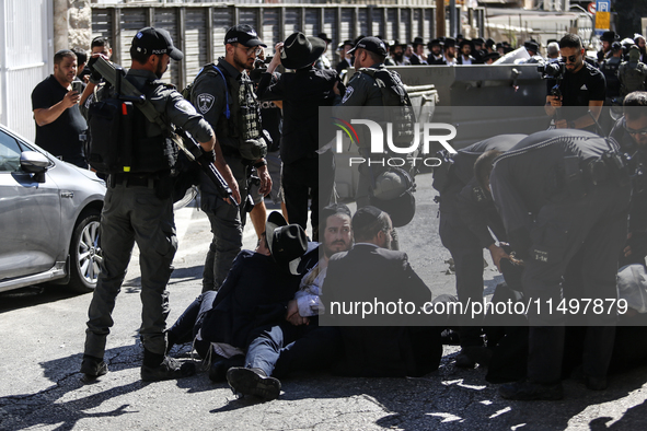 Israeli police officers intervene in Ultra-Orthodox Jews, also known as Haredim, who gather to stage a protest against mandatory military se...