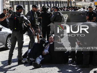 Israeli police officers intervene in Ultra-Orthodox Jews, also known as Haredim, who gather to stage a protest against mandatory military se...