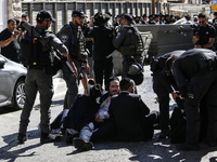 Israeli police officers intervene in Ultra-Orthodox Jews, also known as Haredim, who gather to stage a protest against mandatory military se...