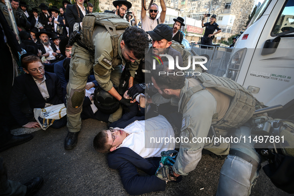 Israeli police officers intervene in Ultra-Orthodox Jews, also known as Haredim, who gather to stage a protest against mandatory military se...