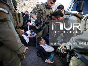 Israeli police officers intervene in Ultra-Orthodox Jews, also known as Haredim, who gather to stage a protest against mandatory military se...