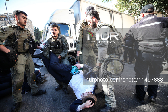 Israeli police officers intervene in Ultra-Orthodox Jews, also known as Haredim, who gather to stage a protest against mandatory military se...