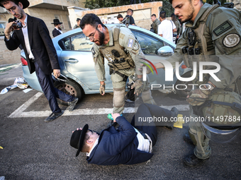 Israeli police officers intervene in Ultra-Orthodox Jews, also known as Haredim, who gather to stage a protest against mandatory military se...