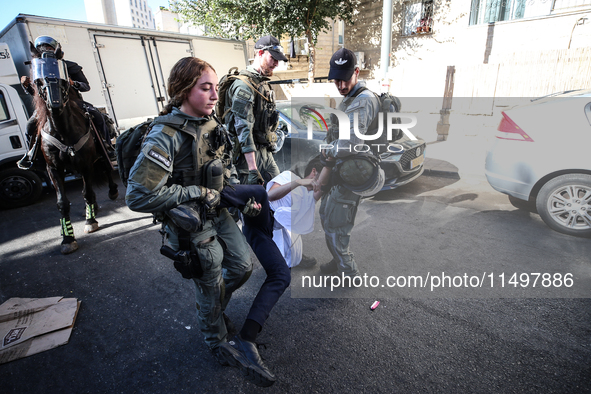 Israeli police officers intervene in Ultra-Orthodox Jews, also known as Haredim, who gather to stage a protest against mandatory military se...