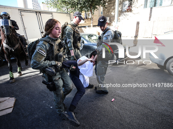 Israeli police officers intervene in Ultra-Orthodox Jews, also known as Haredim, who gather to stage a protest against mandatory military se...