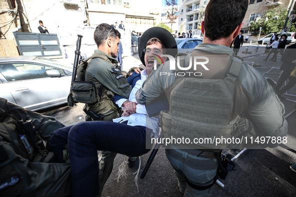 Israeli police officers intervene in Ultra-Orthodox Jews, also known as Haredim, who gather to stage a protest against mandatory military se...