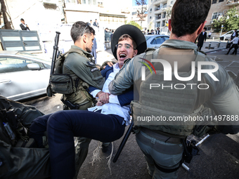 Israeli police officers intervene in Ultra-Orthodox Jews, also known as Haredim, who gather to stage a protest against mandatory military se...