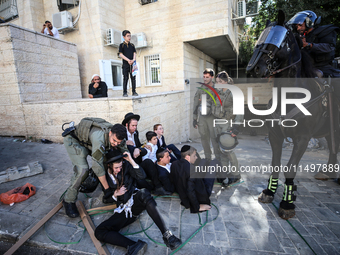 Israeli police officers intervene in Ultra-Orthodox Jews, also known as Haredim, who gather to stage a protest against mandatory military se...