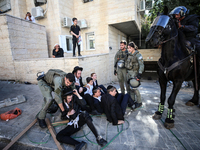 Israeli police officers intervene in Ultra-Orthodox Jews, also known as Haredim, who gather to stage a protest against mandatory military se...