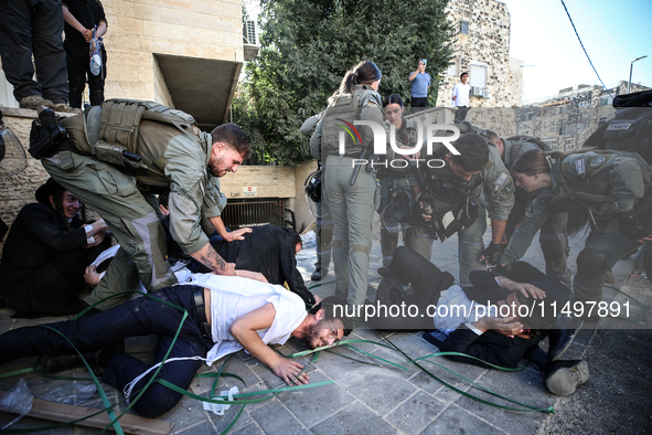 Israeli police officers intervene in Ultra-Orthodox Jews, also known as Haredim, who gather to stage a protest against mandatory military se...