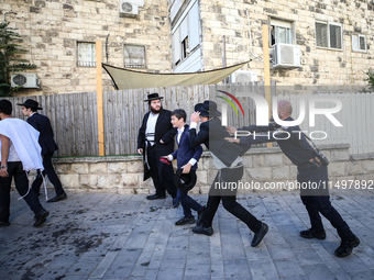 Israeli police officers intervene in Ultra-Orthodox Jews, also known as Haredim, who gather to stage a protest against mandatory military se...