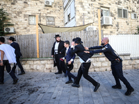 Israeli police officers intervene in Ultra-Orthodox Jews, also known as Haredim, who gather to stage a protest against mandatory military se...