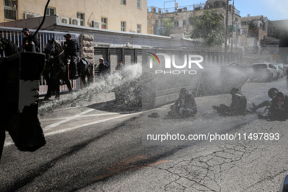 Israeli police officers intervene in Ultra-Orthodox Jews, also known as Haredim, who gather to stage a protest against mandatory military se...