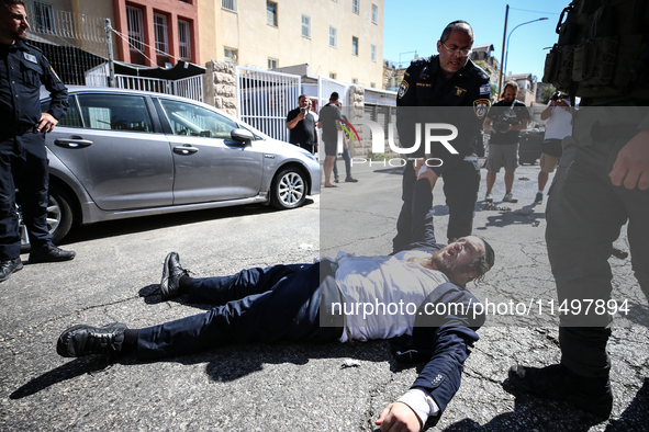 Israeli police officers intervene in Ultra-Orthodox Jews, also known as Haredim, who gather to stage a protest against mandatory military se...