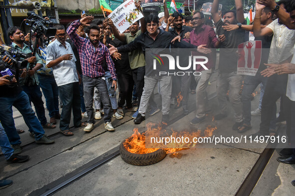 Supporters of the Congress party burn a tire in protest against the rape and murder of a junior doctor in Kolkata, India, on August 21, 2024...