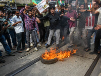 Supporters of the Congress party burn a tire in protest against the rape and murder of a junior doctor in Kolkata, India, on August 21, 2024...