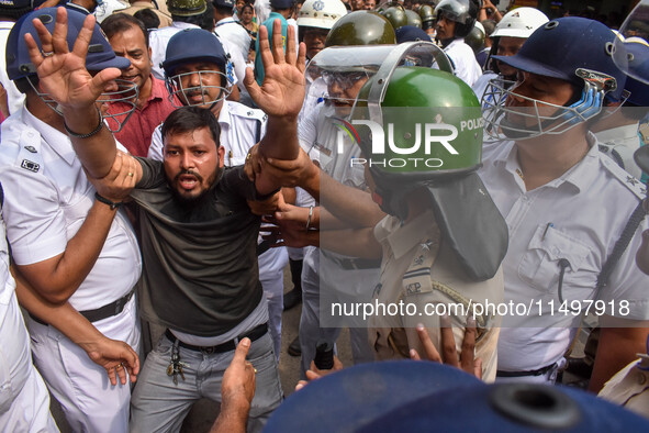 Police arrest supporters of the Indian National Congress during a protest against the rape and murder of a junior doctor in Kolkata, India,...