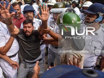 Police arrest supporters of the Indian National Congress during a protest against the rape and murder of a junior doctor in Kolkata, India,...