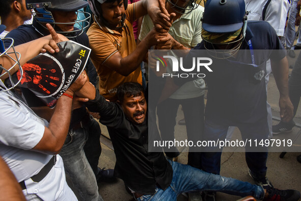 Police arrest supporters of the Indian National Congress during a protest against the rape and murder of a junior doctor in Kolkata, India,...