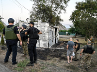 Law enforcers are outside the Levada children's cafe in the central park damaged by a Russian artillery shell strike in Malokaterynivka vill...